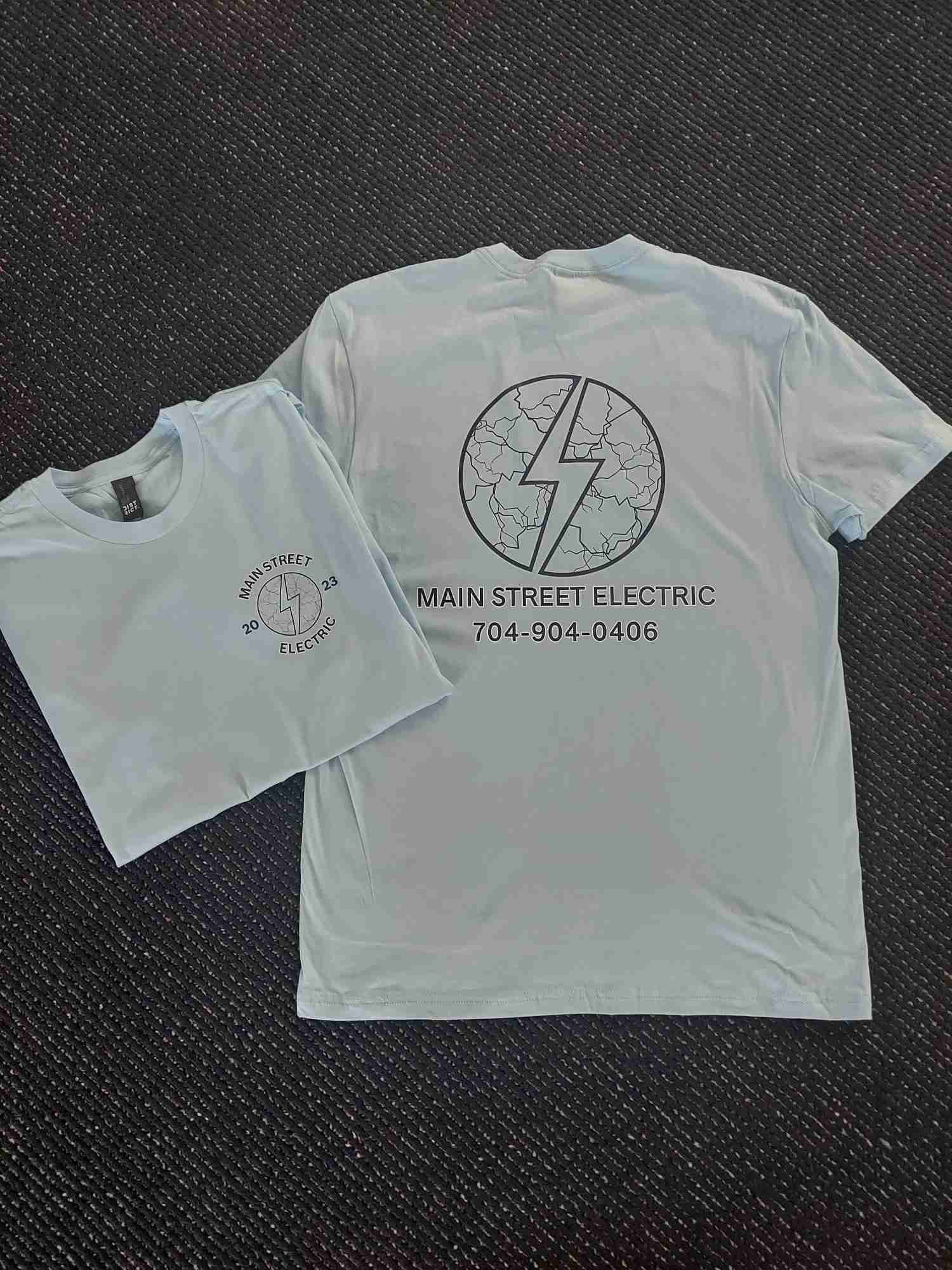 Light blue Main Street Electric work tees screen printed with a front logo and back contact info — Ultimate Swag, Mooresville NC