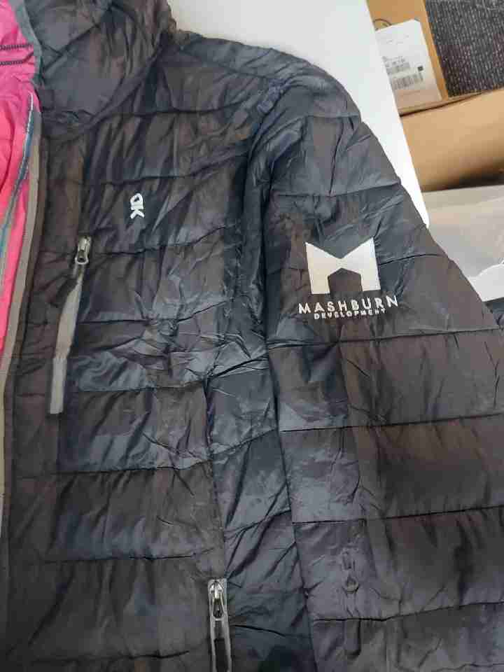 Black puffer jacket with an embroidered Mashburn Development logo on the sleeve — Ultimate Swag, Mooresville NC